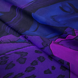 Macro shot of abstract female face print on blue violet fabric with fine woven texture