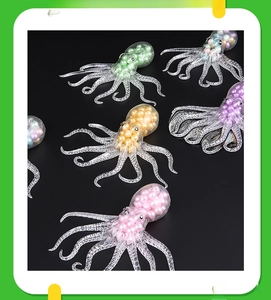 Glow-in-the-dark octopus stress relief toy with colorful beads on a black background