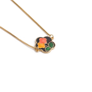 Detail of flower pendant with orange and yellow petals on a gold box chain necklace