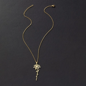 Close-up of golden stainless steel necklace with custom flower and script pendant