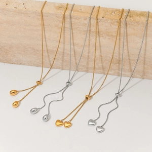 Adjustable gold and silver stainless steel heart and teardrop pendant necklaces on marble