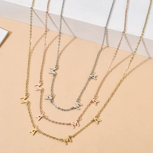 Detailed close-up of MAMA letter pendants in gold, silver, and rose gold finishes