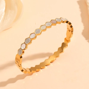 Macro detail of gold honeycomb bracelet featuring white mother of pearl and zircon stones