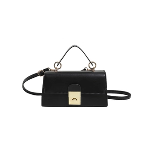 Elegant black leather handbag with gold round metal clasp and adjustable shoulder strap