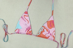 Detailansicht eines rosa Bikini-Tops mit geometrischem Druck und verstellbarem Neckholder