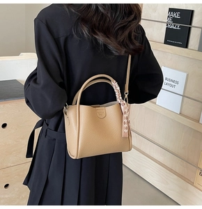 Beige litchi grain tote bag with decorative silk scarf shown cross-body on model