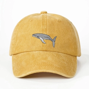 Detail of whale embroidery on ginger yellow washed cotton baseball cap with curved brim