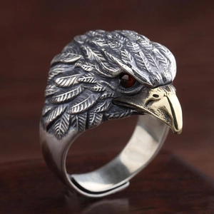 Vintage eagle ring with silver finish and golden beak featuring red gemstone eyes