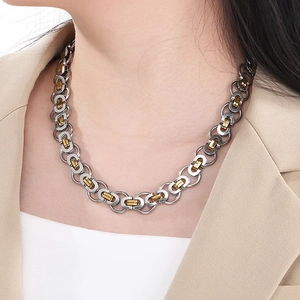 Close-up of a two-tone silver and gold chain necklace worn with a beige blazer