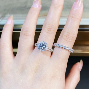 Macro shot of 925 silver ring set with round moissanite and heart shaped stones on finger