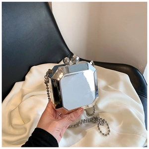 Macro shot of silver geometric acrylic box bag with mirror finish and bead chain strap
