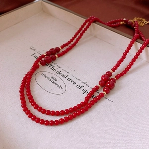 Detail shot of vintage red glass bead necklace with layered strands and gold accents