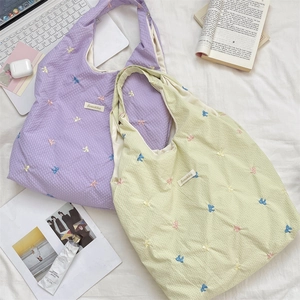 Close-up of waffle fabric texture and colorful butterfly embroidery on casual tote bags