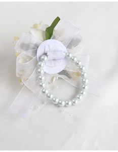 Détail du corsage de poignet blanc avec nœud en organza et base de bracelet en perles
