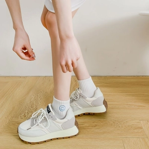 Close-up of white breathable cotton socks with blue smiley face embroidery on the ankle