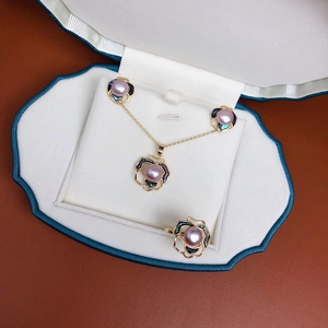 Three-piece freshwater pearl jewelry set with camellia design including necklace, rings, and earrings