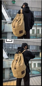 Detail of khaki canvas backpack featuring retro styling and leather trim on urban streets