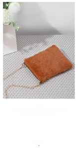 Detail of warm brown faux fur crossbody bag with elegant gold metal chain strap
