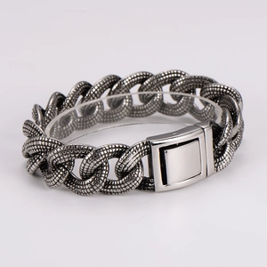 Close-up of vintage silver curb chain bracelet with textured scales and polished buckle