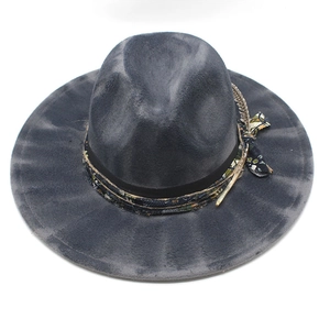 Detail of dark grey wool fedora with ethnic woven band and feather accent on white background