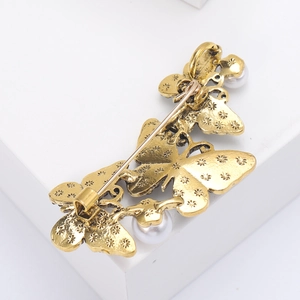 Close-up of the vintage gold butterfly brooch back pin and white pearl settings