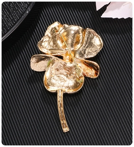 Detail view of the gold enamel iris brooch back showing the pin fastener and texture