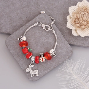 Detailed shot of Christmas charm bracelet with red crystals, silver skulls and donkey pendant