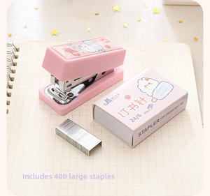 Dettaglio di mini cucitrice rosa con punti metallici su sfondo di quaderno a quadretti