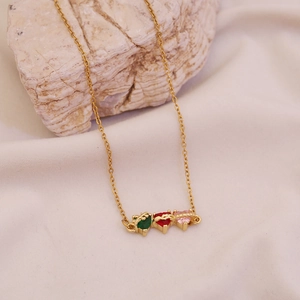 Gold titanium steel necklace with colorful heart pendants on a natural rock background