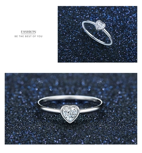 Macro detail of s925 silver heart ring with sparkling crystal on starry background