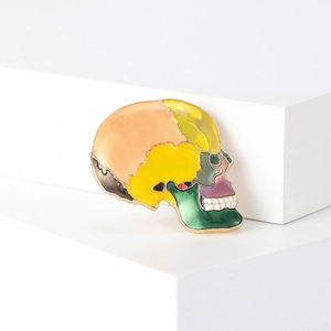 Colorful enamel skull brooch in gold finish for fashion accessories on white stand