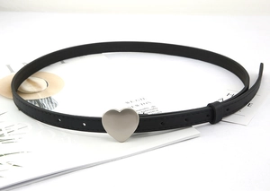 Detail of minimalist black leather belt featuring a silver heart-shaped metal buckle