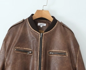 Détail d'une veste vintage en cuir PU marron avec col côtelé et poche à fermeture éclair