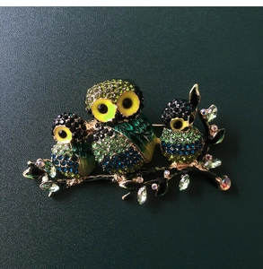 Close-up of owl trio brooch featuring colorful crystals and intricate alloy detail