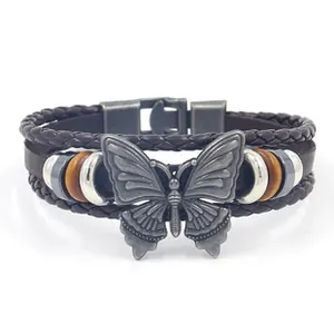 Macro view of multi-layer leather bracelet featuring an engraved silver butterfly charm