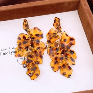 Macro detail of amber leopard print acrylic petal tassels on long drop earrings