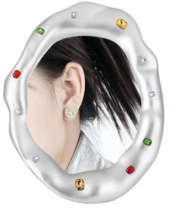 Macro shot of silver wave textured frame with colorful gems and two-tone round studs
