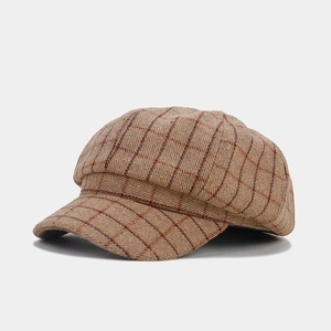Close-up of retro brown plaid newsboy cap showing detailed wool blend fabric texture