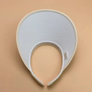 Detail of white leather texture and beige straw weave on an open top sun visor hat