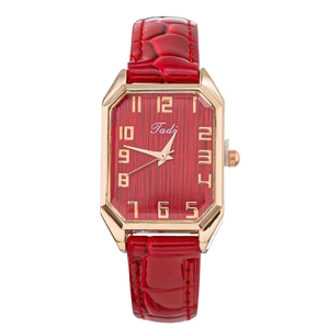 Macro detail of red rectangular watch with crocodile texture leather strap and gold case