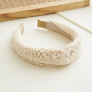 Detail of classic beige knitted wide headband featuring soft wool-like plush texture
