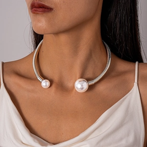 Close-up of silver torque choker with large faux pearls on a model's neck