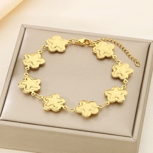 Close-up of golden flower charms bracelet with lobster clasp on jewelry display case