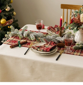 Close-up of red plaid Christmas table runner and napkins with golden snowflakes