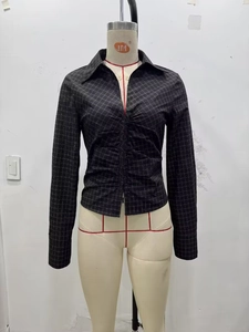 Close-up of ruched front detail on a slim-fit black and white checkered shirt
