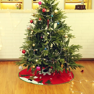 Red Christmas tree skirt with snowman applique on wood floor for holiday home decoration
