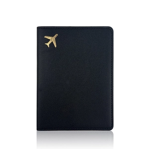 Black litchi leather passport holder with golden airplane design and mirror reflection