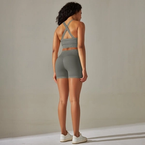Détail du design croisé au dos sur un ensemble de sport de yoga tricoté gris-vert sans couture