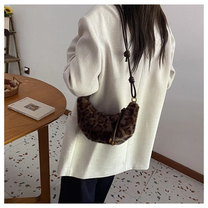 Détail du sac croissant en peluche léopard avec bandoulière en cuir sur l'épaule