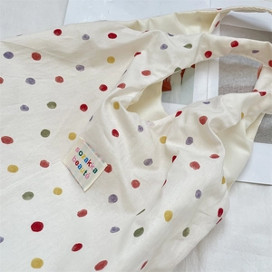 Vue détaillée du sac en toile à pois colorés avec étiquette de marque tissée
